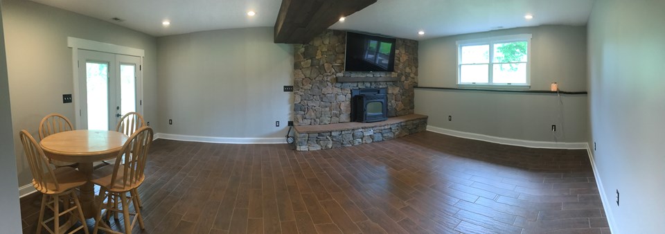 newly remodeled basement large entertaining space with walkout that leads to backyard oasis
