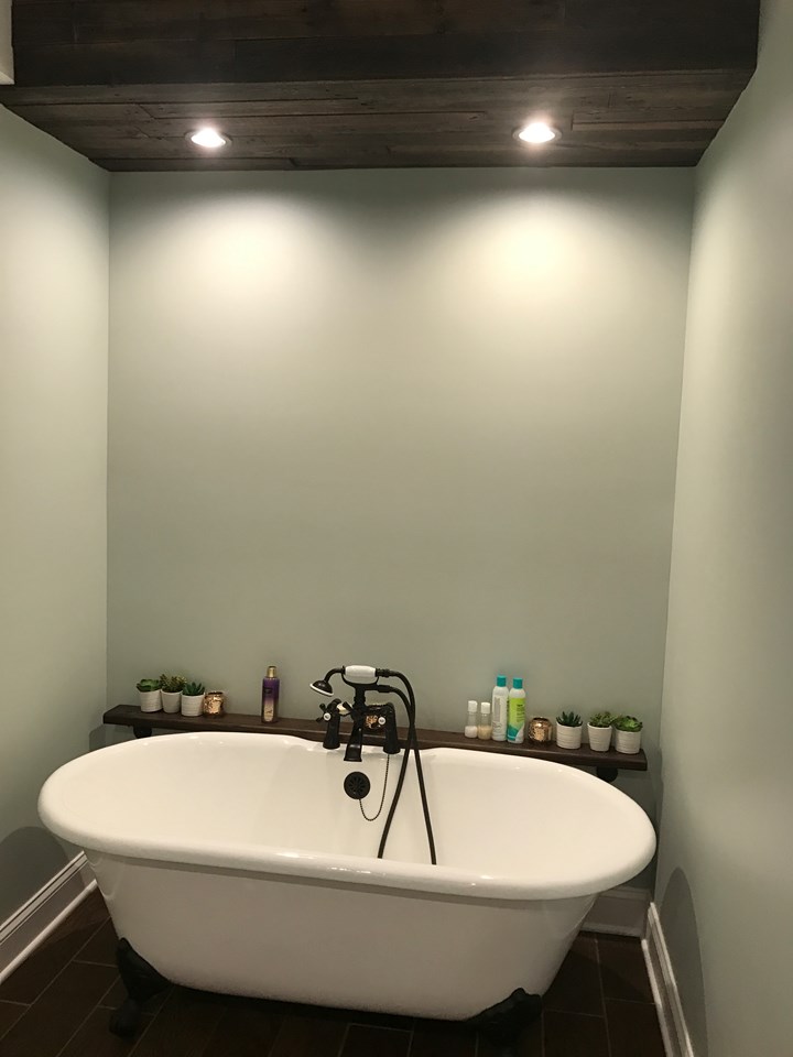 lavish bathroom lavish bath features cast iron claw foot tub, wine barrel sink, wood lined bulkhead w/ recess lighting.