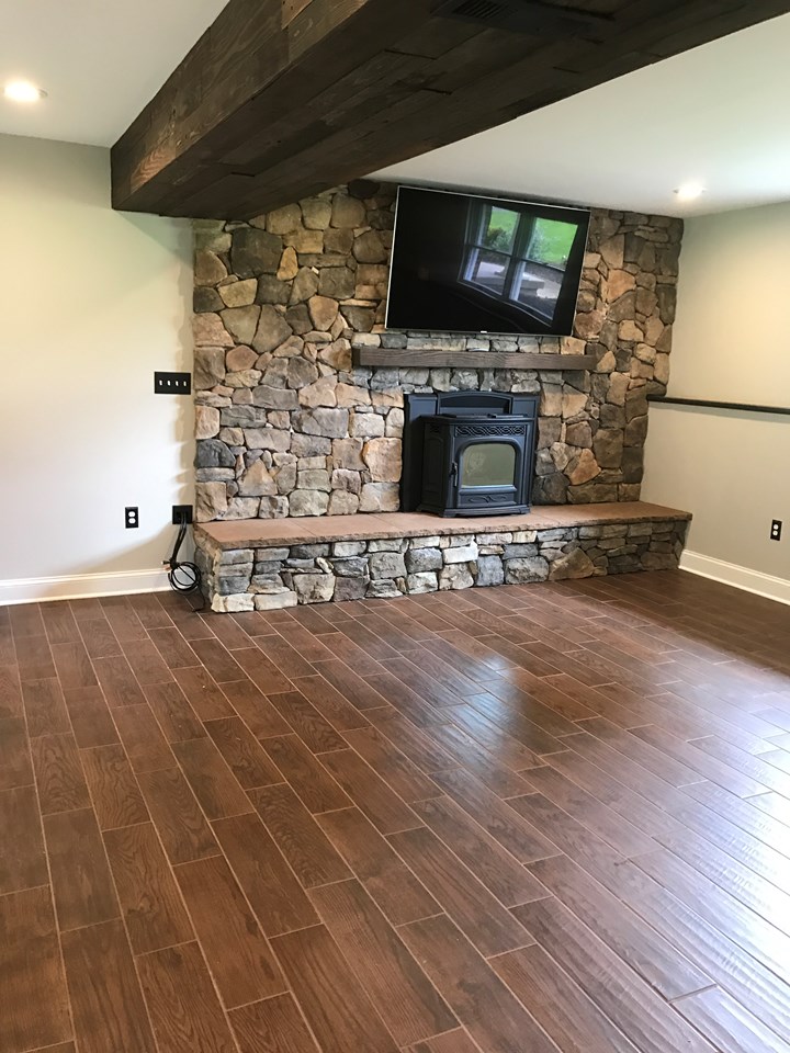 newly remodeled basement newly remodeled basement w/custom upgrades-stoned fireplace, wood lined bulkheads, ceramic floor, handmade barn doors, rustic lighting